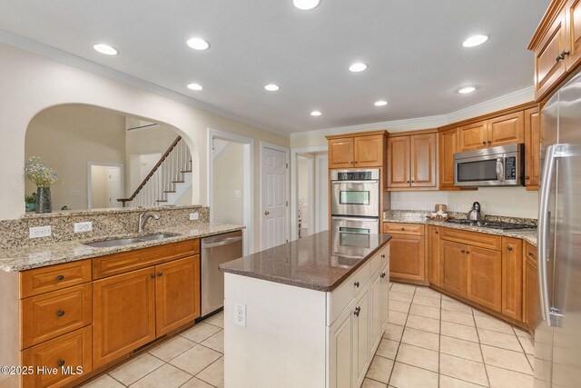 232 E Ivybridge Dr, Hubert, NC 28539 - kitchen featuring appliances with stainless steel finishes, a sink, crown molding, arched walkways, and light tile patterned floors