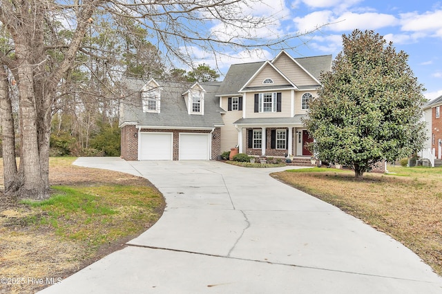 view of front of home with a garage, brick siding, covered porch, driveway, and roof with shingles