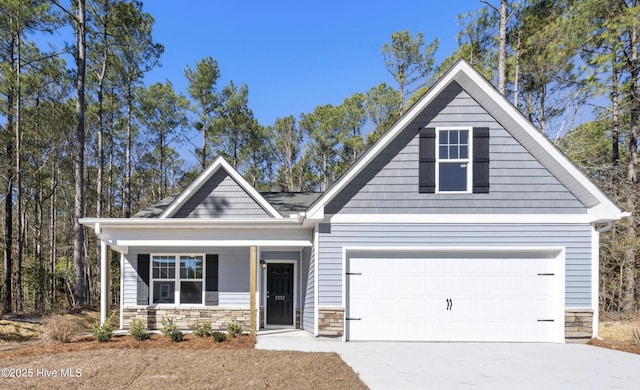 craftsman-style house with driveway and stone siding