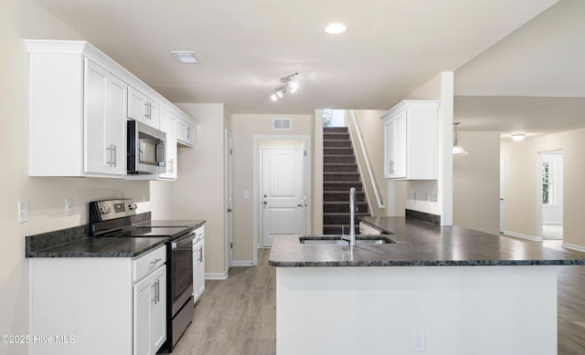 kitchen featuring sink, appliances with stainless steel finishes, white cabinetry, kitchen peninsula, and light wood-type flooring