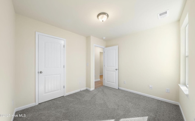 unfurnished bedroom featuring visible vents, baseboards, and carpet floors