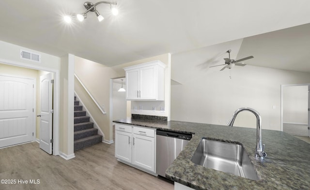 kitchen featuring sink, white cabinetry, light hardwood / wood-style flooring, dark stone countertops, and dishwasher