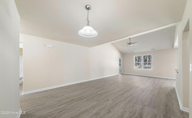 unfurnished living room featuring baseboards, vaulted ceiling, a ceiling fan, visible vents, and wood finished floors