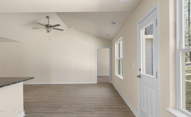 unfurnished living room with wood-type flooring, ceiling fan, and vaulted ceiling