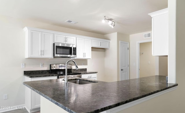 kitchen featuring a peninsula, visible vents, white cabinetry, and appliances with stainless steel finishes