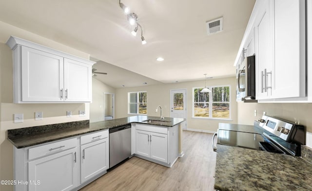 kitchen with a peninsula, light wood-style floors, visible vents, stainless steel appliances, and a sink