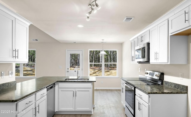 kitchen with white cabinets, light wood-style floors, visible vents, appliances with stainless steel finishes, and a sink