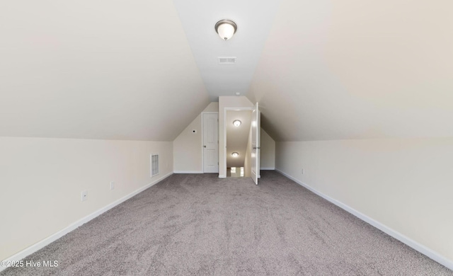 additional living space featuring visible vents, carpet floors, baseboards, and vaulted ceiling
