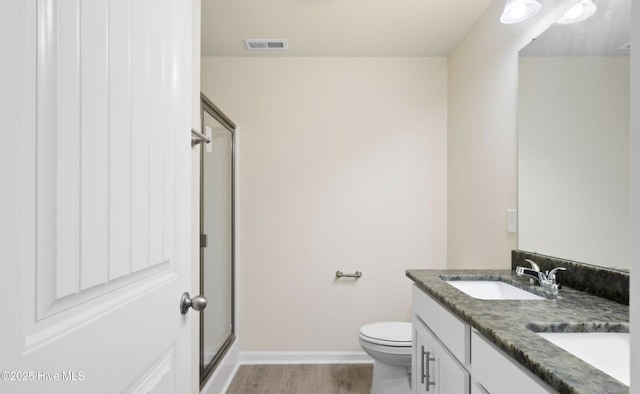 bathroom with a sink, visible vents, a shower stall, and wood finished floors