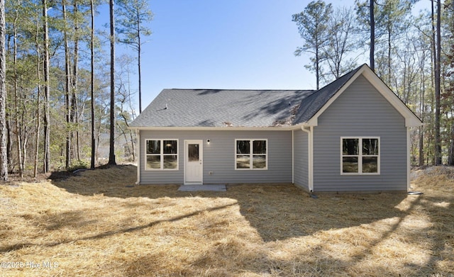 rear view of property with a shingled roof