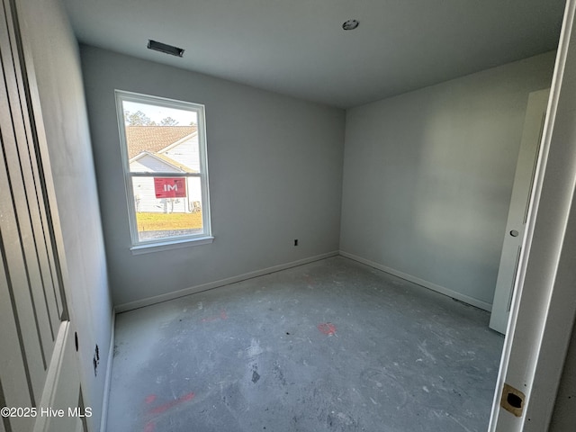empty room featuring concrete floors and baseboards