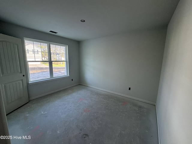 spare room with concrete floors, visible vents, and baseboards