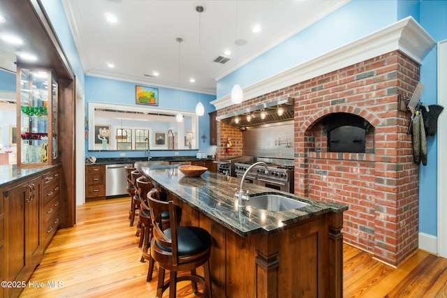 811 Hwy 70 Davis, Davis, NC 28524 - kitchen with light wood-type flooring, dark stone countertops, a kitchen island with sink, a kitchen breakfast bar, and crown molding