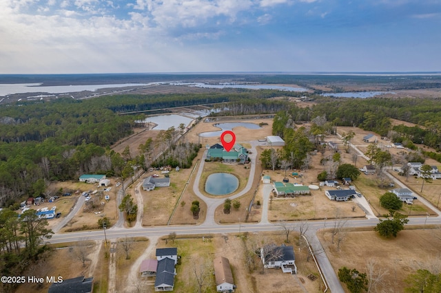 aerial view with a wooded view and a water view