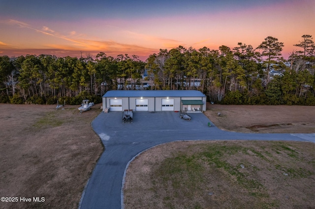 view of front of property featuring a garage, an outdoor structure, and driveway