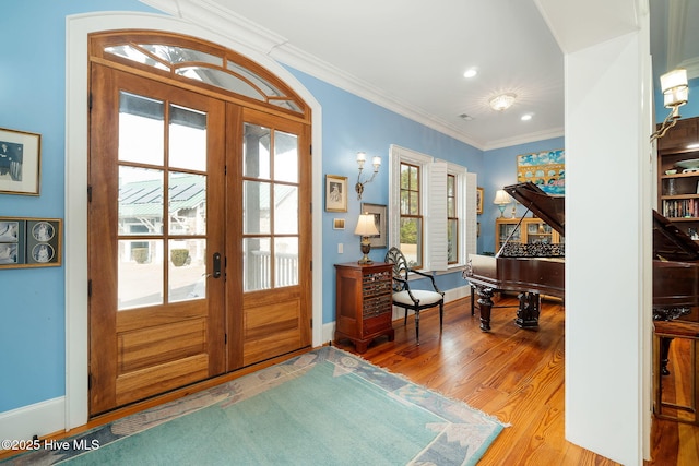 entryway with ornamental molding, wood finished floors, recessed lighting, french doors, and baseboards