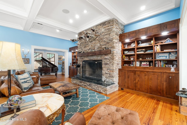 living room with beamed ceiling, light wood-style flooring, coffered ceiling, and a stone fireplace