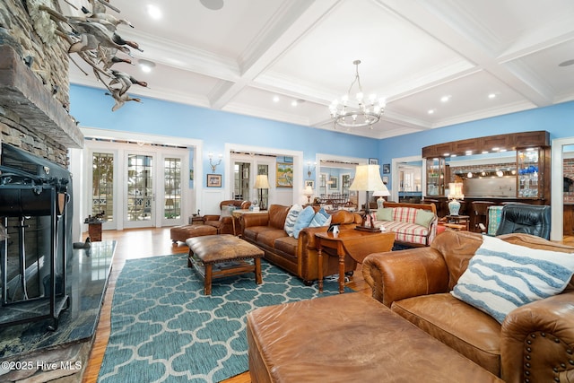 living room featuring wood finished floors, coffered ceiling, beam ceiling, a fireplace, and french doors