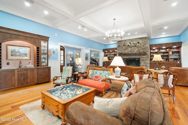 living area with light wood-type flooring, beamed ceiling, coffered ceiling, and visible vents