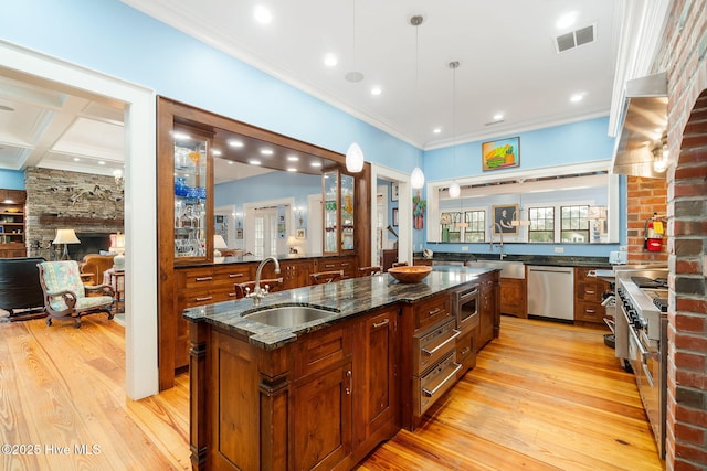 kitchen featuring a sink, ornamental molding, stainless steel appliances, light wood-style floors, and a warming drawer