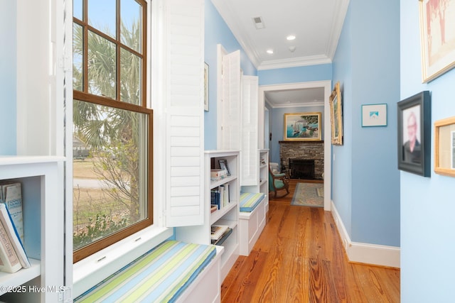 hall with light wood-type flooring, visible vents, recessed lighting, crown molding, and baseboards