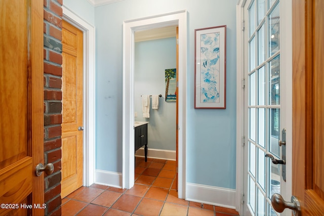 hall featuring tile patterned flooring and baseboards