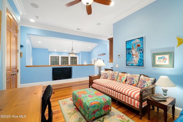 living room with crown molding, wood finished floors, baseboards, and visible vents