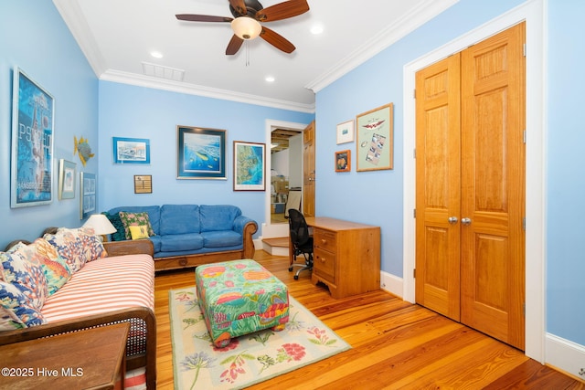 living room with ceiling fan, light wood-style flooring, visible vents, and ornamental molding