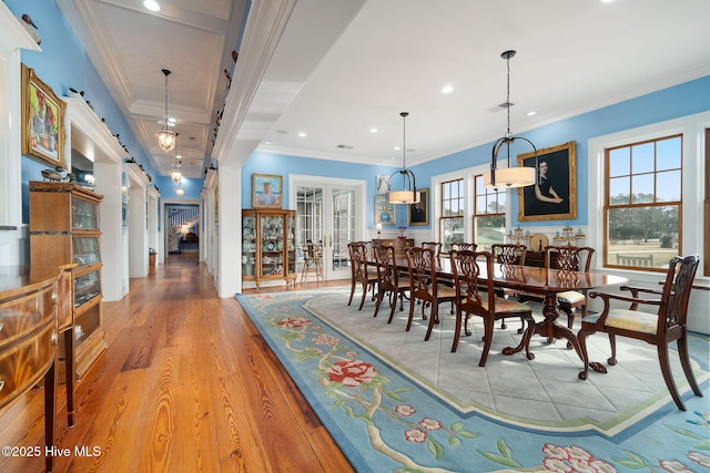 dining room with a barn door, recessed lighting, crown molding, and light wood-style floors