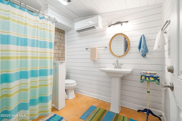 full bathroom with toilet, a shower with shower curtain, a wall mounted air conditioner, concrete flooring, and a sink