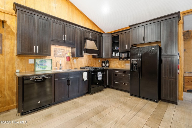 kitchen with lofted ceiling, a sink, black appliances, custom range hood, and dark brown cabinetry