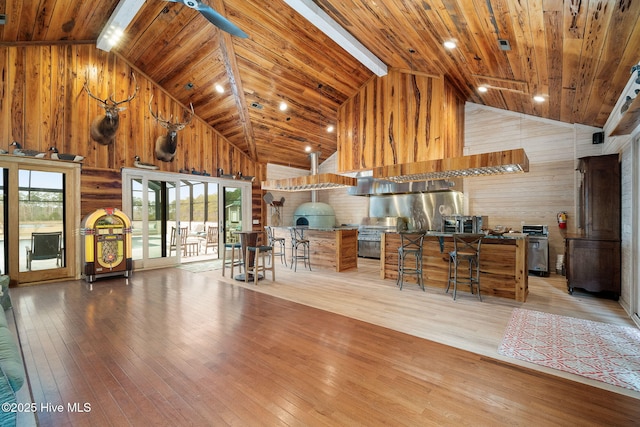 kitchen with hardwood / wood-style flooring, wooden walls, wood ceiling, and high vaulted ceiling