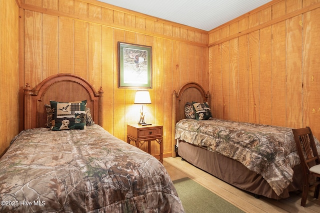 bedroom with wood finished floors and wood walls