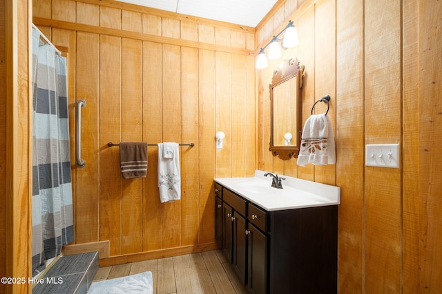 bathroom with wooden walls, vanity, a shower with curtain, and wood finished floors