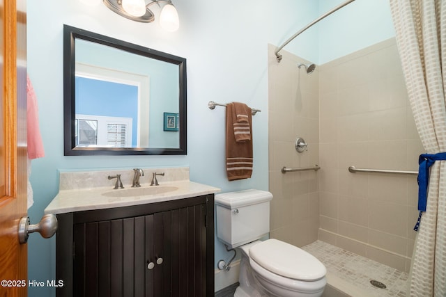 bathroom featuring vanity, toilet, and tiled shower