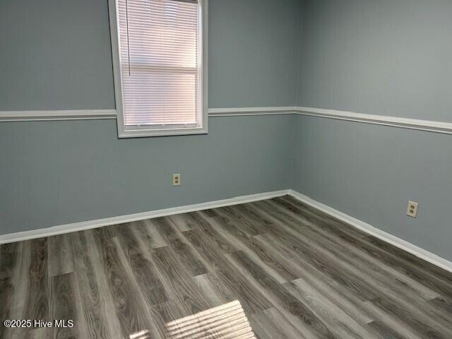 unfurnished room featuring dark hardwood / wood-style flooring