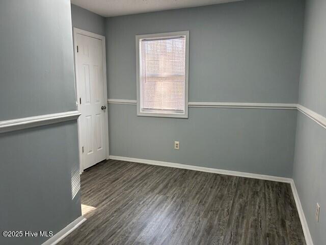 unfurnished room featuring dark wood-type flooring