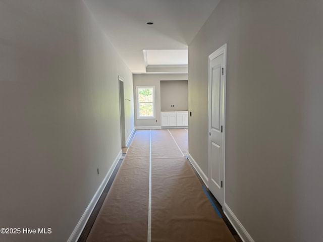 hall featuring baseboards and carpet