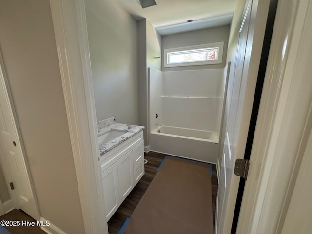 full bathroom featuring washtub / shower combination, wood finished floors, and vanity
