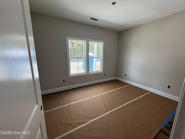 spare room with baseboards and visible vents