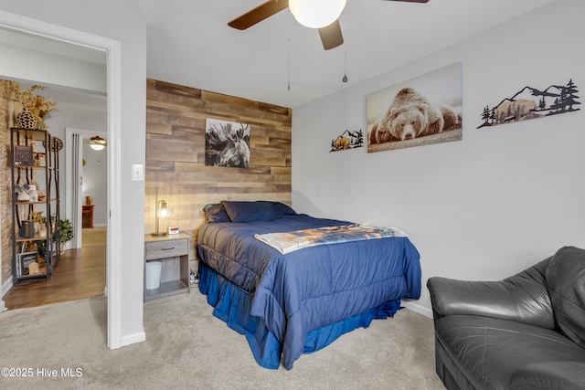 bedroom featuring carpet, ceiling fan, and wood walls