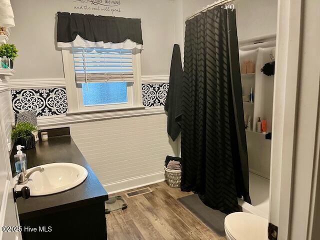 bathroom featuring vanity, toilet, and hardwood / wood-style floors