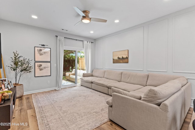 living room featuring light hardwood / wood-style floors and ceiling fan