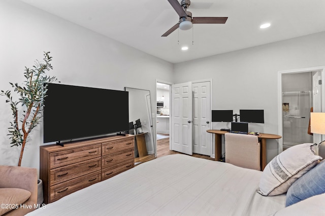 bedroom with ensuite bathroom, wood-type flooring, and ceiling fan