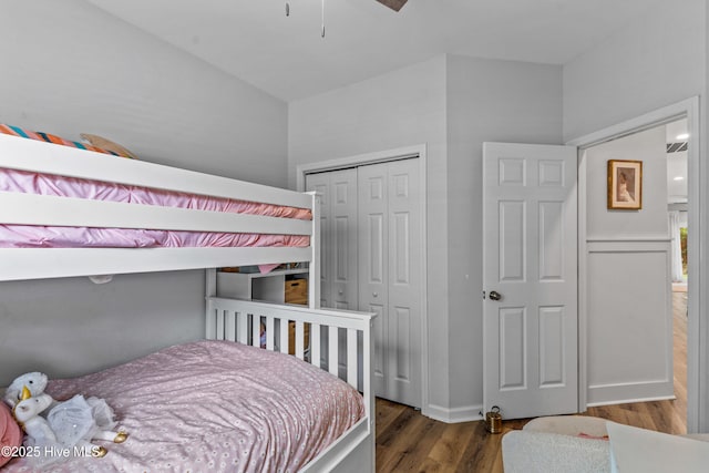 bedroom with dark hardwood / wood-style flooring and a closet