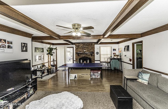 living room featuring beam ceiling, plenty of natural light, a brick fireplace, and a textured ceiling