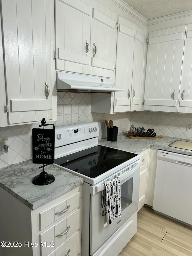 kitchen featuring tasteful backsplash, under cabinet range hood, light wood-style floors, white appliances, and white cabinetry