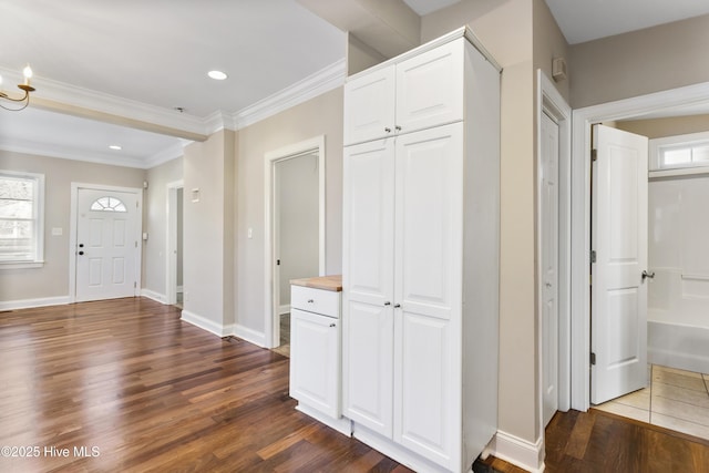 foyer entrance featuring recessed lighting, baseboards, dark wood-type flooring, and ornamental molding