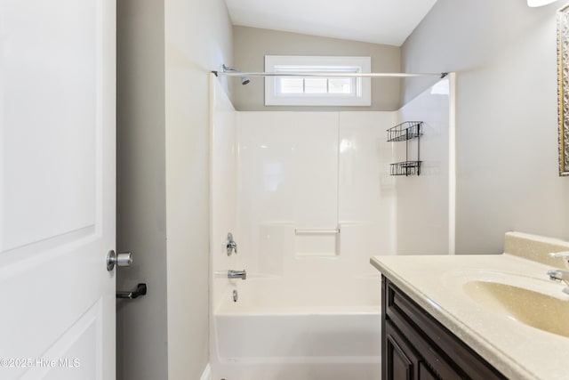 bathroom with vanity,  shower combination, and vaulted ceiling