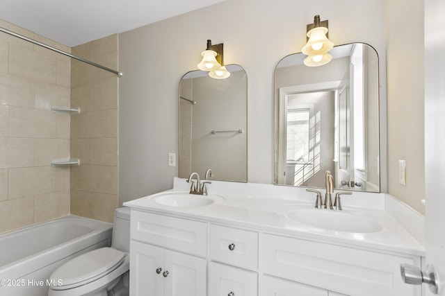 full bathroom featuring double vanity, toilet, shower / washtub combination, and a sink